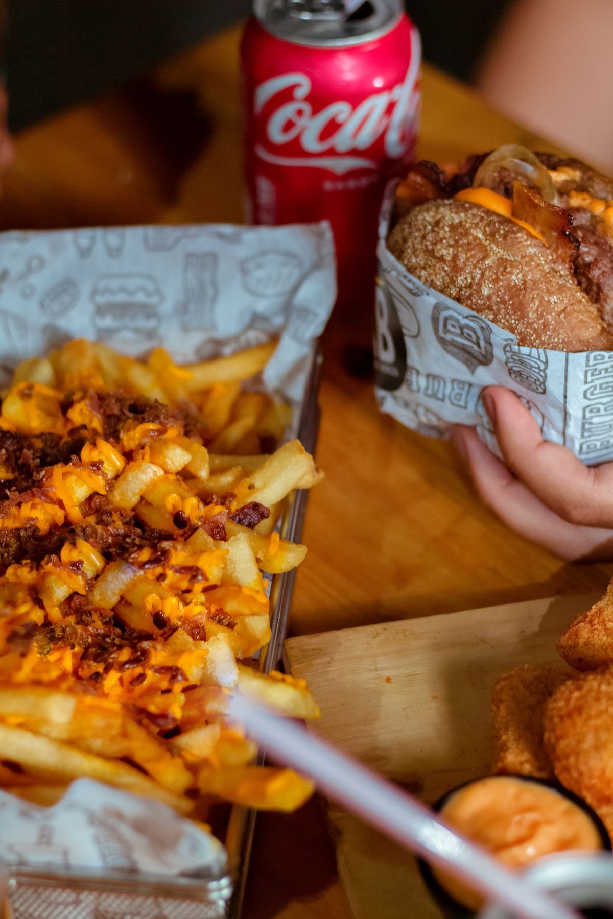 A burger, fries and a cola set out on a table