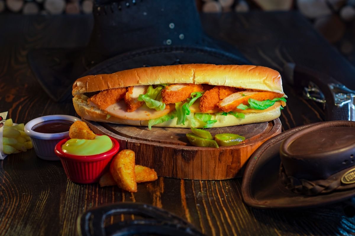 A fried chicken sandwich served with dips and crispy sides, used as an editorial illustration for “Ebi Filet-O: Japan’s shrimp sandwich”