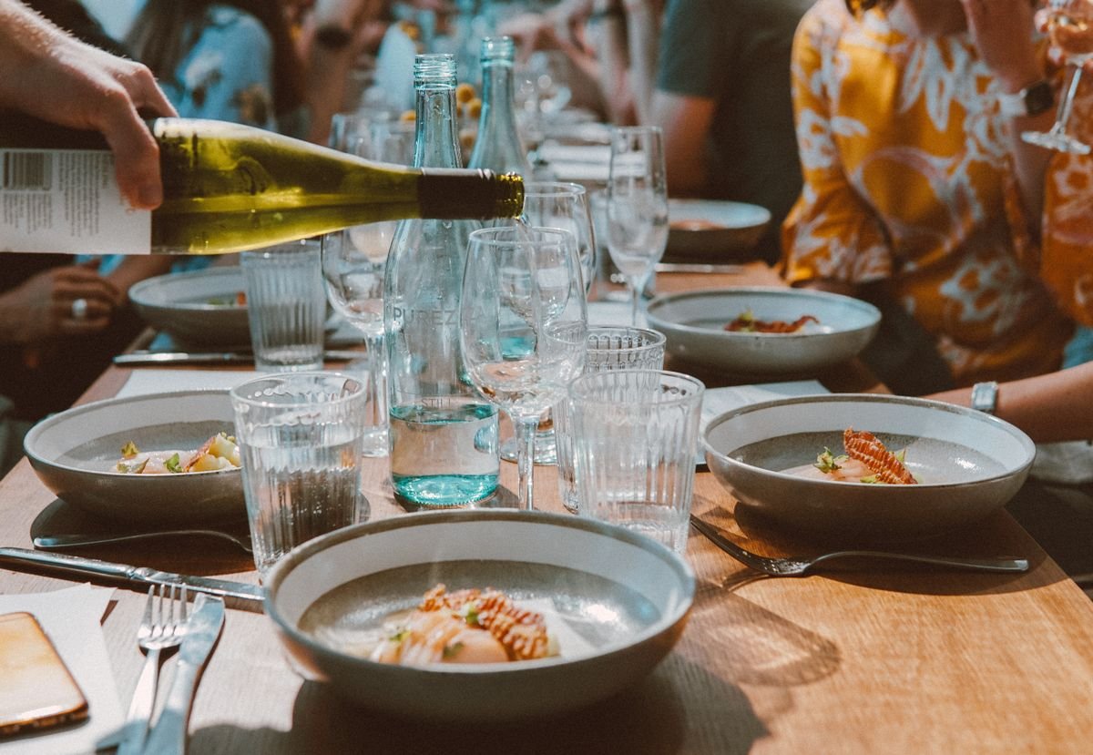 Diners sharing wine and meals at a busy restaurant table in Sydney